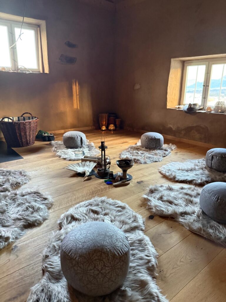 Warme Atmosphäre in der Seelenstube mit Feuerstelle und Sitzkreis für persönliche Entwicklung